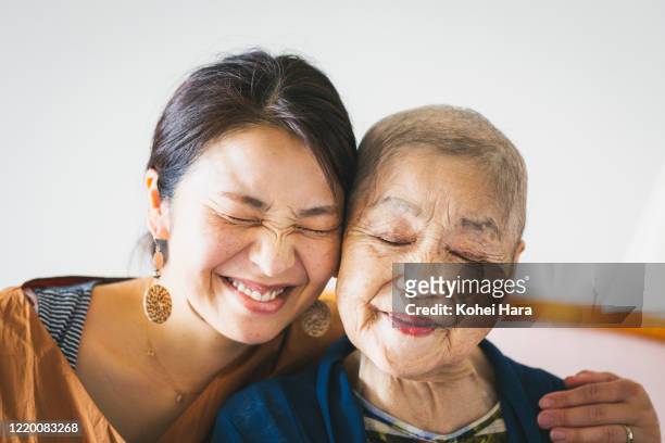 portrait of old mother with cancer and her middle aged daughter - hair loss stock pictures, royalty-free photos & images