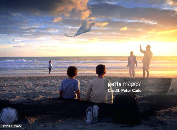 family on beach at sunset - flying dad son stock pictures, royalty-free photos & images