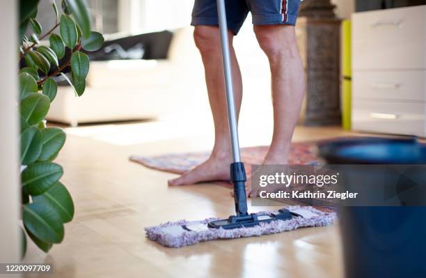 man cleaning living room floor with mop, low section - mop up stock pictures, royalty-free photos & images