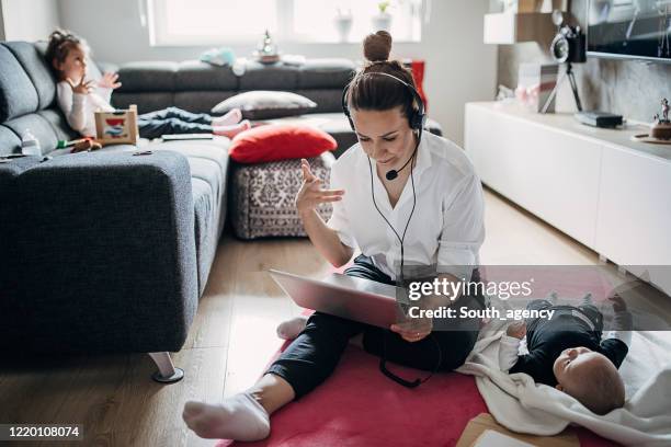 beschäftigte alleinerziehende mutter arbeitet zu hause und babysitting - multitasking stock-fotos und bilder