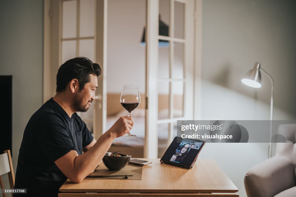 Japanese man drinks wine with his girlfriend over video call virtual dinner
