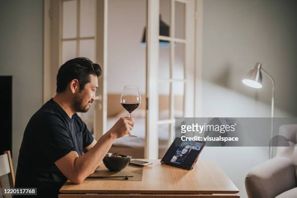 japanese man drinks wine with his girlfriend over video call virtual dinner - evening meal stock pictures, royalty-free photos & images