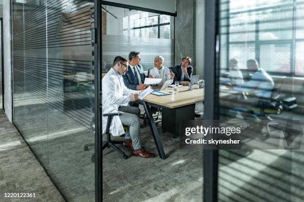 male entrepreneurs talking to medical experts on a meeting in the office. - clean suit stock pictures, royalty-free photos & images