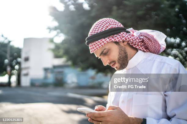 arab middle east man using mobile phone at street - saudi telecom stock pictures, royalty-free photos & images