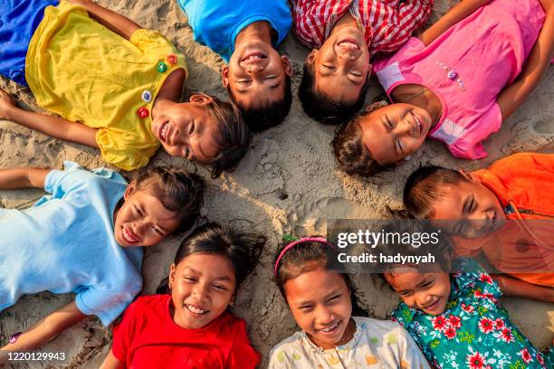 group of cambodian children lying in a circle on sand, cambodia - 9 circles in a circle stock pictures, royalty-free photos & images
