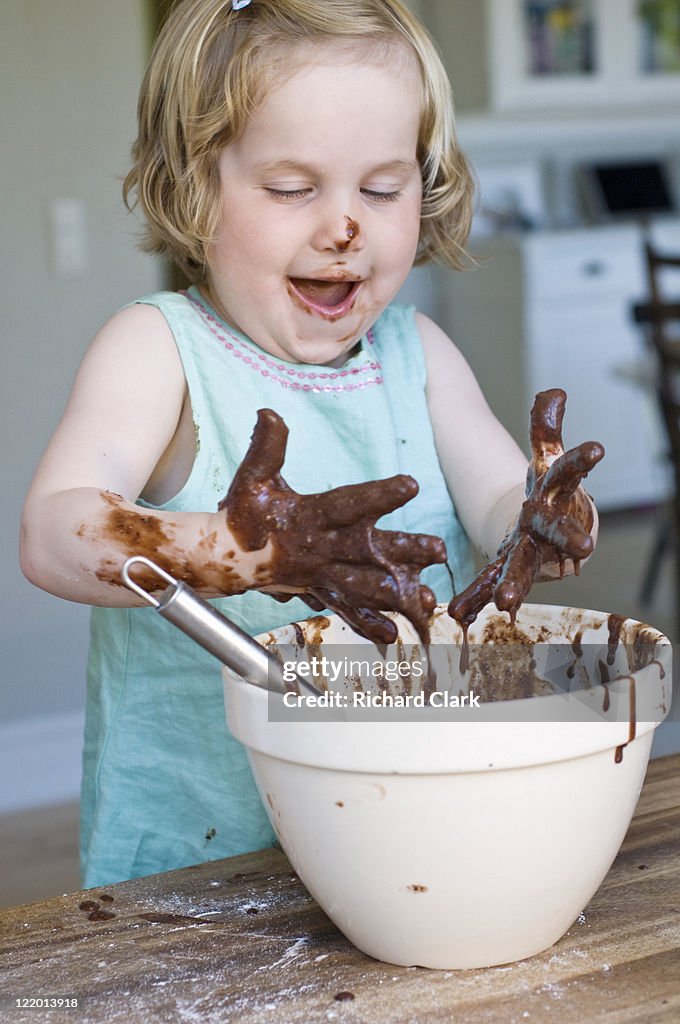 Girl (3-5 years) making chocolate sauce