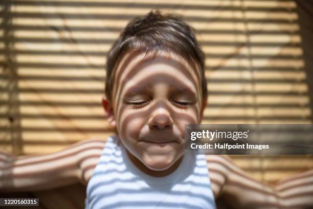 view from above of small boy lying down on floor indoors at home. - schaduwe stockfoto's en -beelden