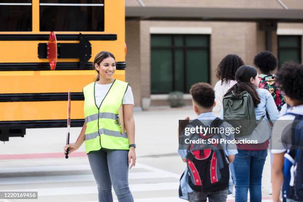 mid adult female crossing guard listens to young boy - public school building stock pictures, royalty-free photos & images