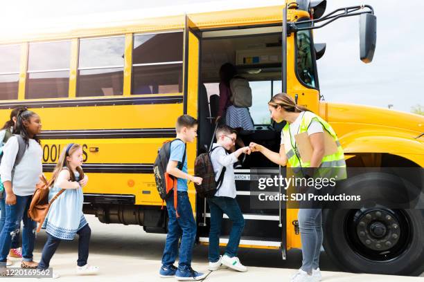 les étudiants donnent des coups de poing au chauffeur d’autobus - bus scolaire photos et images de collection