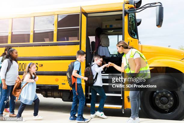 students give fist bumps to bus driver - school bus stock pictures, royalty-free photos & images