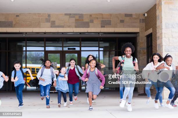 excited schoolchildren leaving school - last day of school stock pictures, royalty-free photos & images