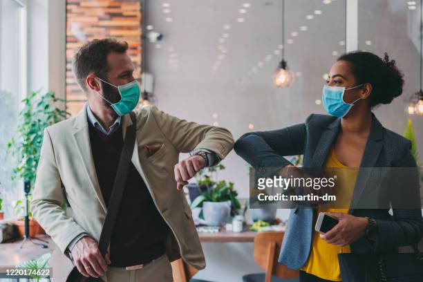 geschäftsleute grüßen während covid-19 pandemie, ellenbogenstoß - corona virus stock-fotos und bilder