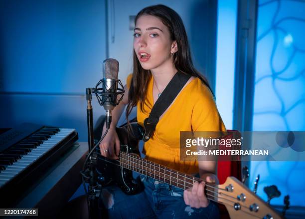 brunett tonåring musiker sångerska flicka sjunger och spelar bas gitarr telefonkonferens - bass player bildbanksfoton och bilder