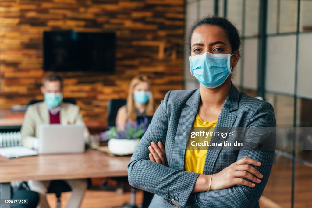 Businesspeople working with face masks in the office during COVID-19 pandemic