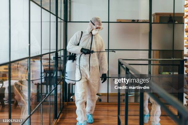 desinfección de la oficina durante la pandemia de covid-19 - antiséptico fotografías e imágenes de stock