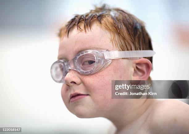 young boy has sly look at a swim meet. - swimming goggles stock pictures, royalty-free photos & images