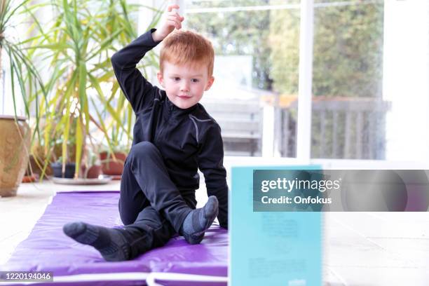 little redhead boy doing home yoga workout - alleen jongens stockfoto's en -beelden