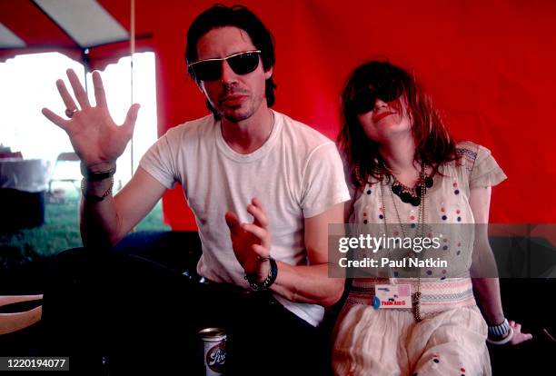 Portrait of American Punk and Rock musicians John Doe and Exene Cervenka, both of the group X, as they sit backstage during the Farm Aid 2 benefit...