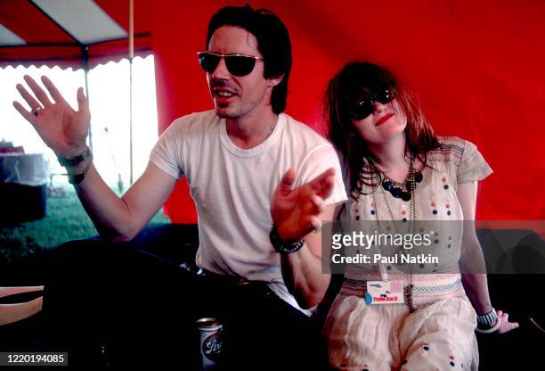 Portrait of American Punk and Rock musicians John Doe and Exene Cervenka, both of the group X, as they sit backstage during the Farm Aid 2 benefit...