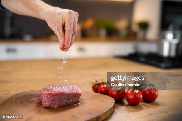 chef adding salt to meat - sprinkling salt stock pictures, royalty-free photos & images