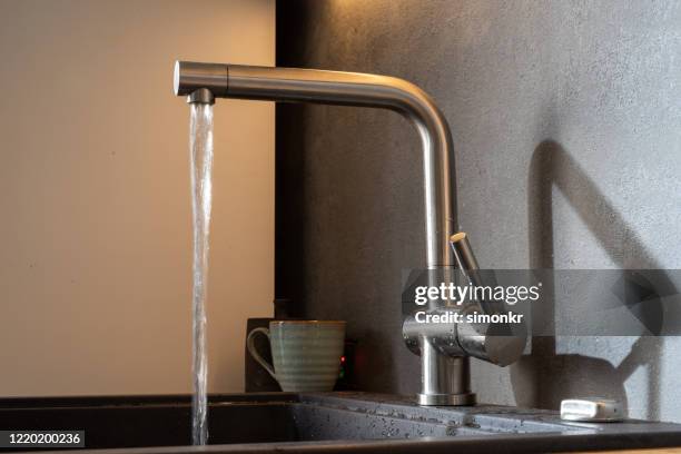 fließender wasserhahn - wasser ressource stock-fotos und bilder