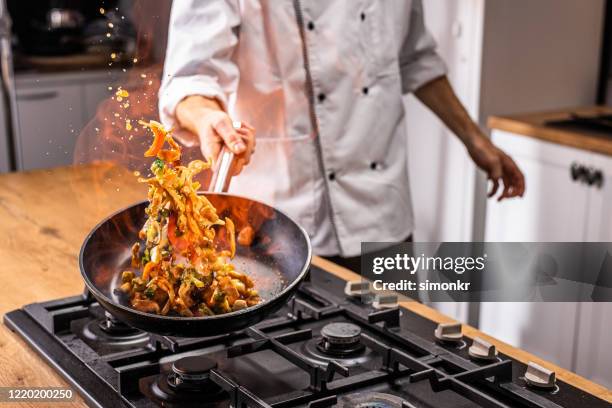 chef cocinando verduras en sartén - action cooking fotografías e imágenes de stock