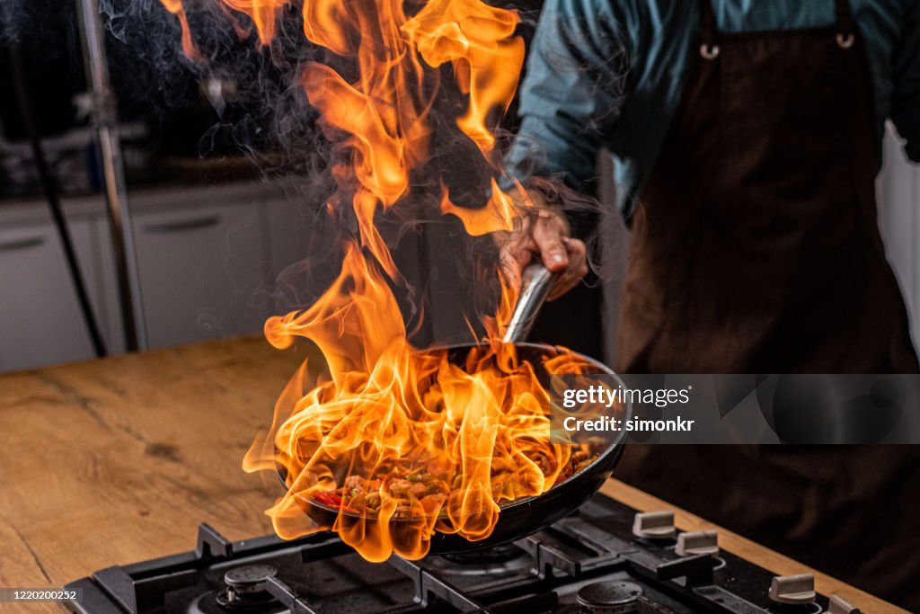 Chef cooking vegetables in pan