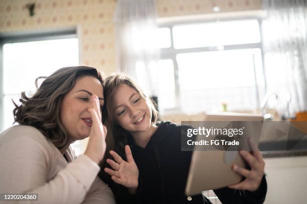 moeder en dochter op een video roepend gebruikend digitale tablet thuis - mother daughter webcam stockfoto's en -beelden