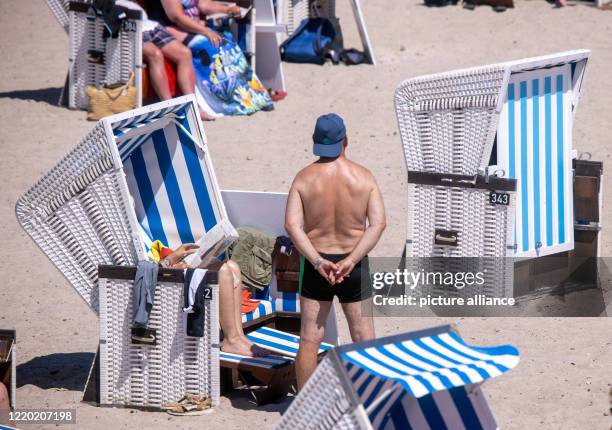 June 2020, Mecklenburg-Western Pomerania, Warnemünde: Holidaymakers bask in their beach chairs on the Baltic coast of Warnemünde. In...