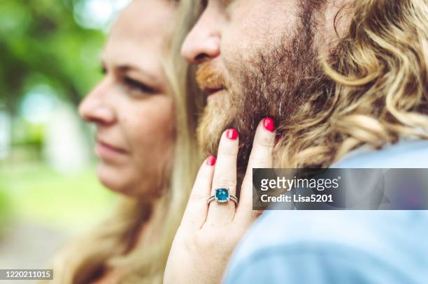 mujer lleva anillo de compromiso no tradicional en un primer plano de pareja comprometida - topaz fotografías e imágenes de stock