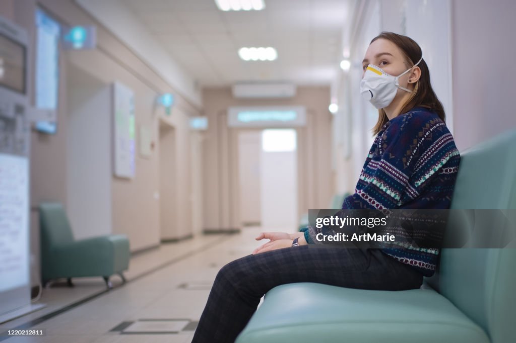 Young girl wearing protective mask in medical clinic