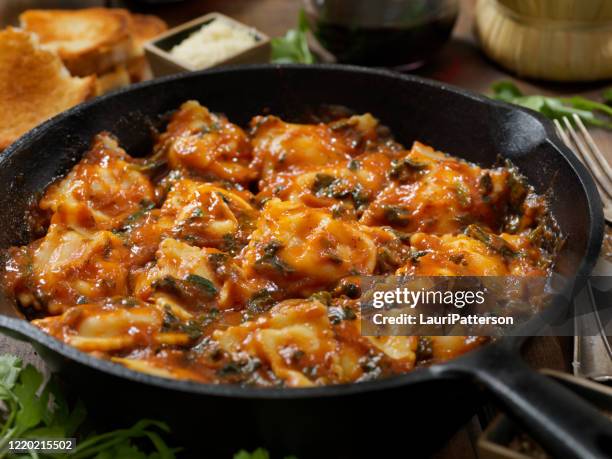 ravioli in a spinach and tomato sauce - iron wine stock pictures, royalty-free photos & images