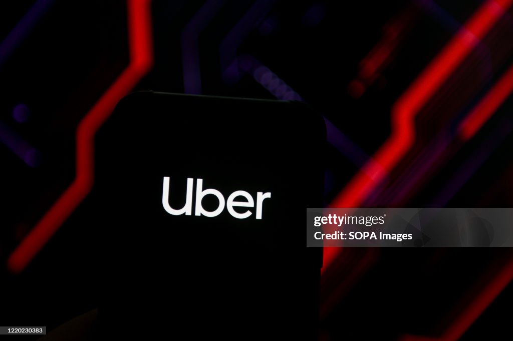 In this photo illustration an Uber logo seen displayed on a...