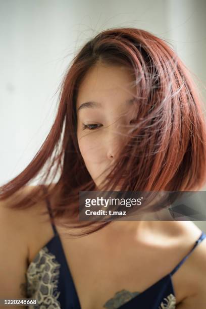a woman who cuts her hair dyed red. - hair care stock pictures, royalty-free photos & images