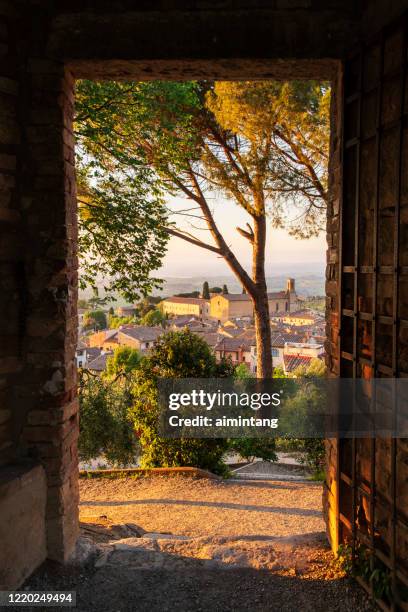 sonnenuntergang durch die türinste stadt in san gimignano - san gimignano stock-fotos und bilder