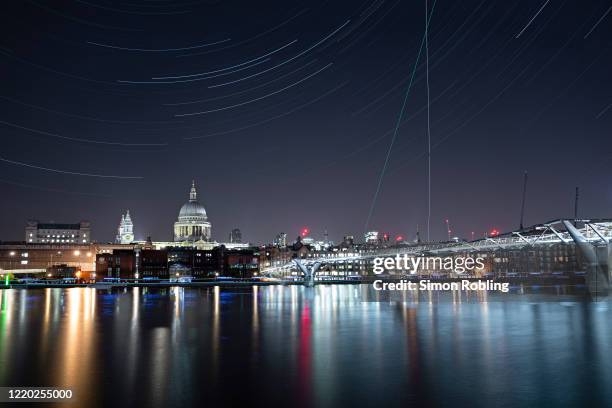 The London Millennium Footbridge is illuminated under the stars on a clear night on April 22, 2020 in London, England. The clear skies created by the...