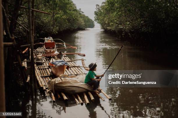 giovane ragazzo pesca - bamboo raft foto e immagini stock