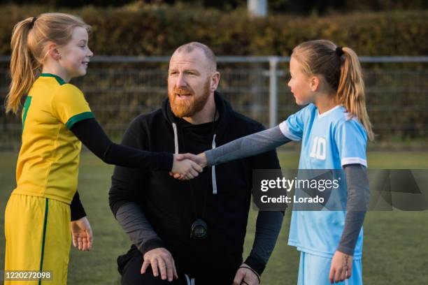 padre de fútbol entrenando equipo de la hija de fútbol durante una sesión de entrenamiento - subs bench fotografías e imágenes de stock