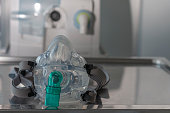 Non-invasive ventilation face mask, on background medical ventilator in ICU in hospital.