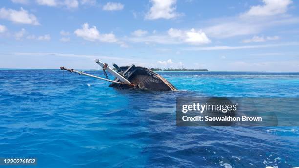 old wooden boat sank in the deep sea in maldives - sunken stockfoto's en -beelden