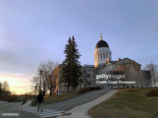 capital building in augusta, maine with man walking by on sidewalk - augusta maine stock pictures, royalty-free photos & images