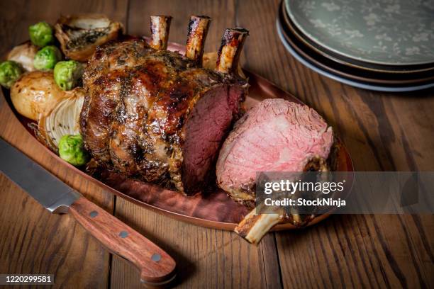 rack of lamb with one piece cut of. - cordeiro imagens e fotografias de stock