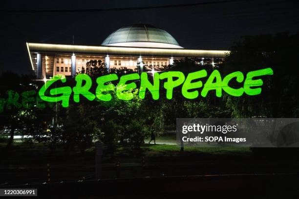 Greenpeace logo is seen on a hologram screen in front of the National Assembly Building. Greenpeace Seoul office took a hologram performance to...