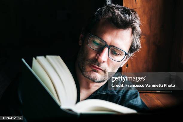 man reading a book. - occhiali da lettura foto e immagini stock