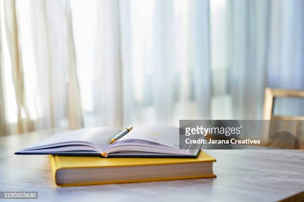 table with books - notepad table stock pictures, royalty-free photos & images