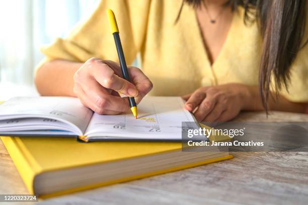 woman writes on her datebook - agenda imagens e fotografias de stock