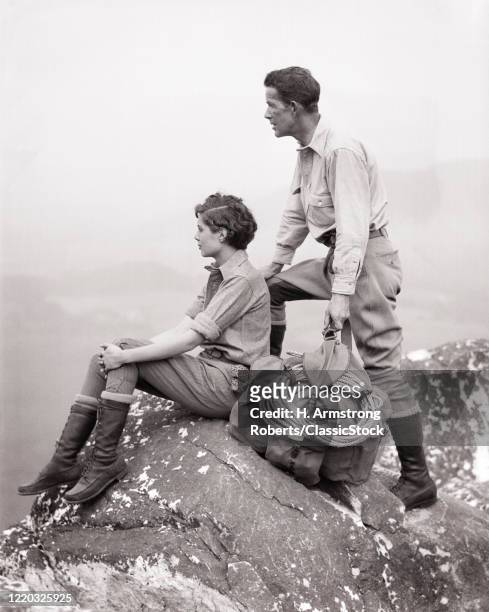 1920s 1930s climbers hikers man and woman taking in the view from the tip of the berkshires monument mountain massachusetts USA