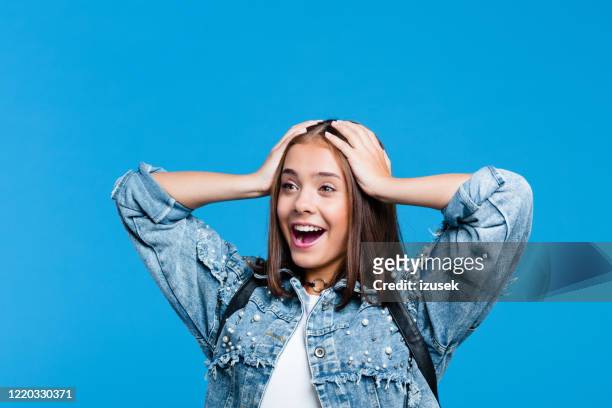retrato de adolescente emocionado contra fondo azul - surprise fotografías e imágenes de stock
