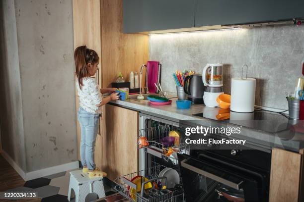 little girl having fun while washing coffee mug - plastic plate stock pictures, royalty-free photos & images