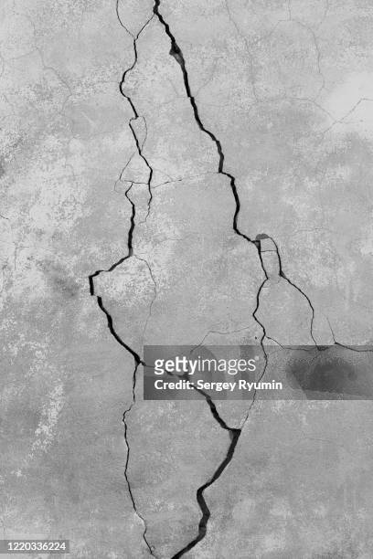 cracked concrete wall in gray - ひびが入った ストックフォトと画像